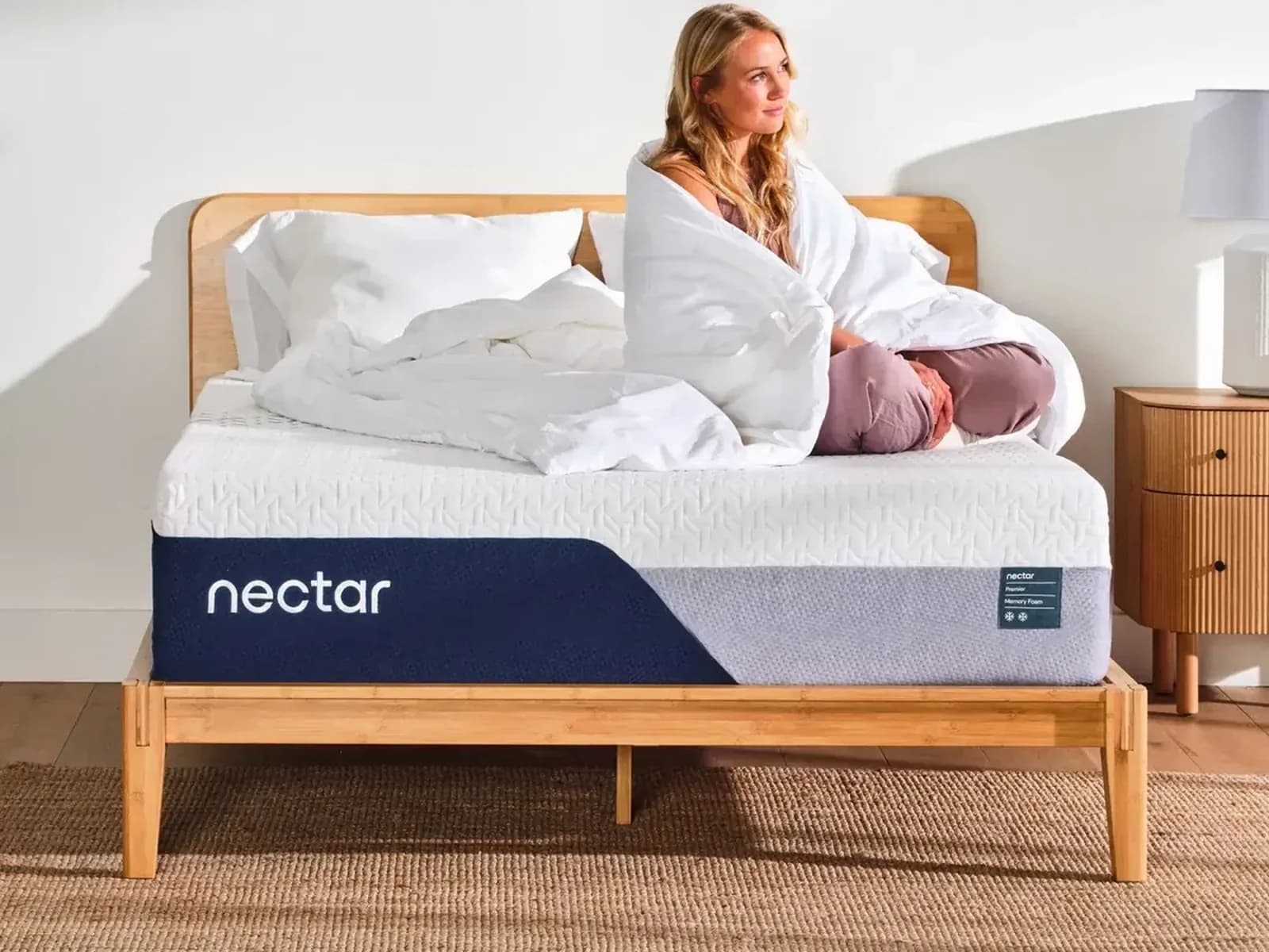 Nectar Premier mattress on a wooden bed frame in a bright bedroom