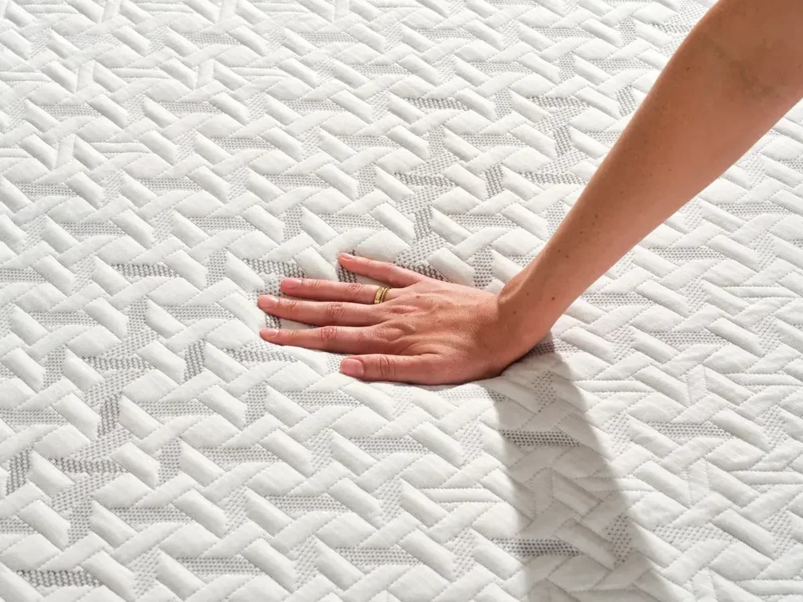 Hand pressing the quilted cover of a Nectar Premier mattress